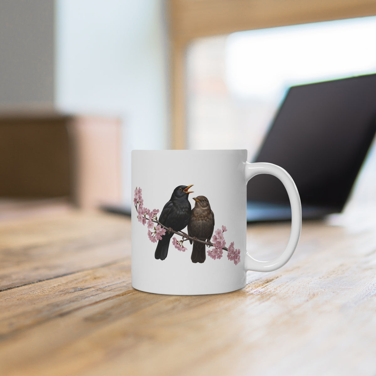 White mug with bird design on a wooden surface