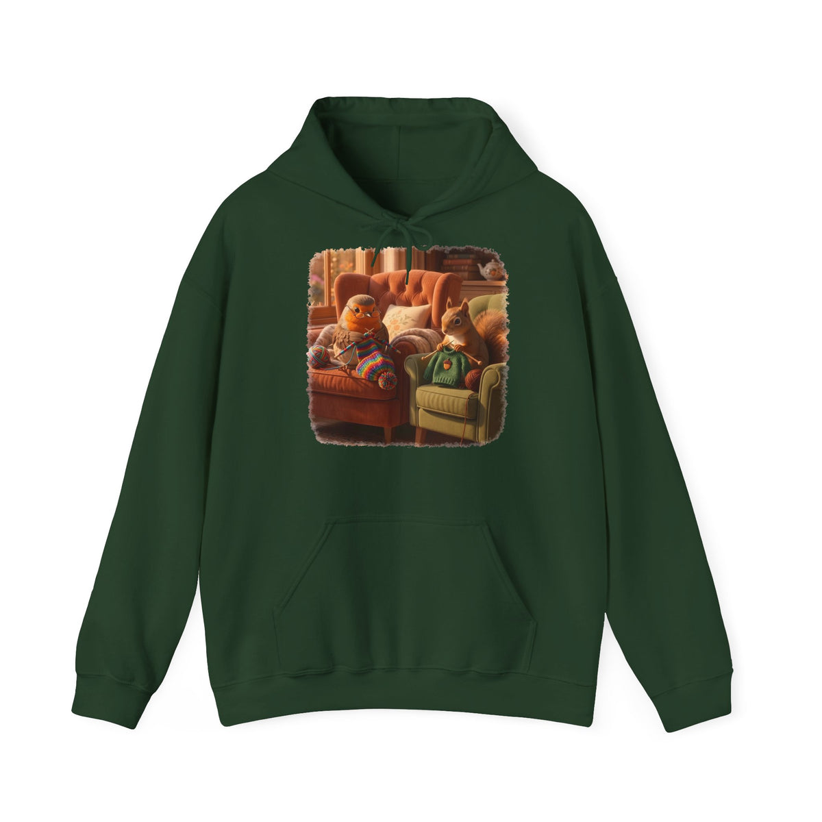 Ein dunkelgrüner Kapuzenpullover mit einem quadratischen Grafikdruck auf der Brust, der eine gemütliche Wohnzimmerszene zeigt: Ein Rotkehlchen sitzt neben einem Eichhörnchen im grünen Pullover auf einem Sessel, und beide stricken.