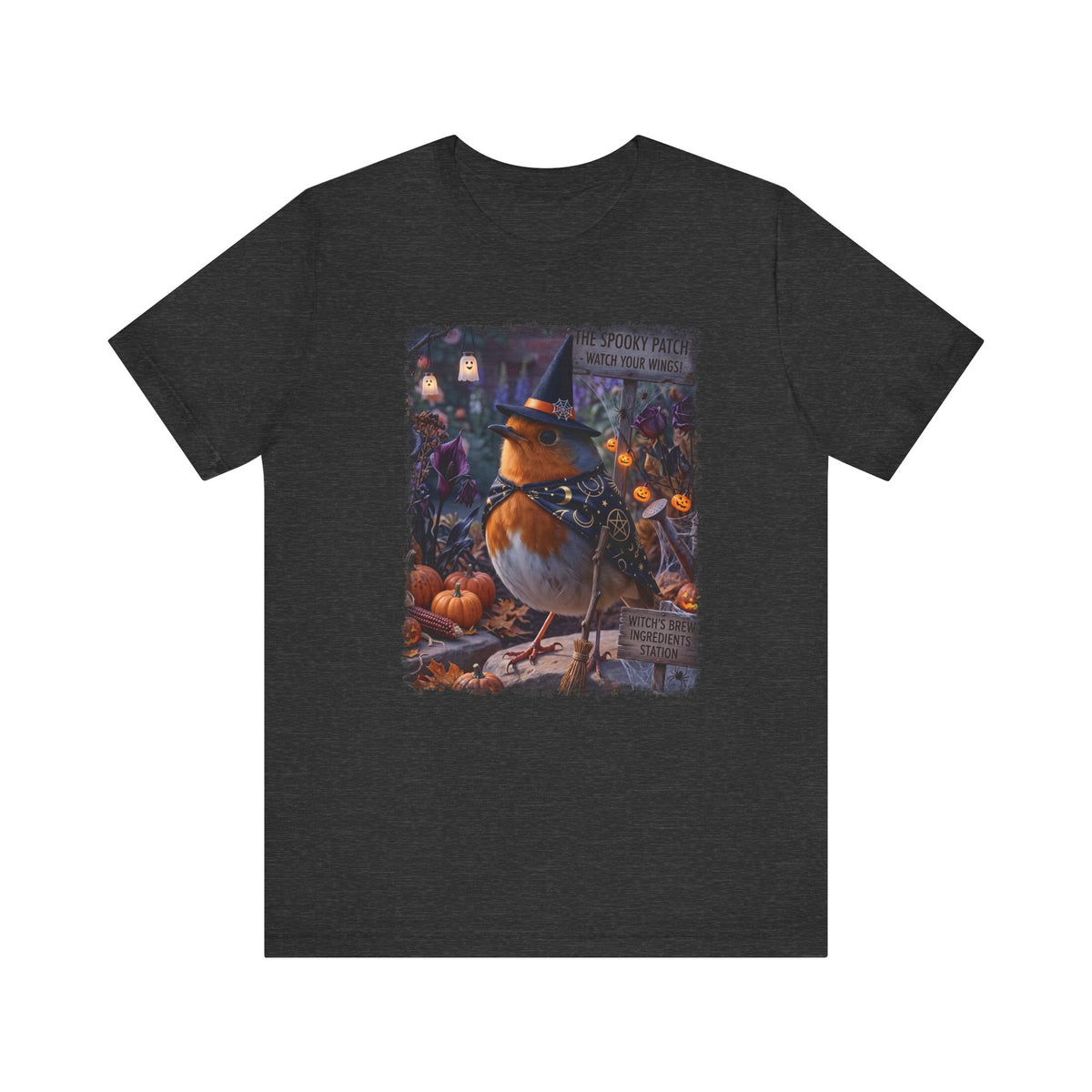 A dark heather gray short-sleeve t-shirt with a colorful graphic print of a robin wearing a witch hat surrounded by pumpkins and autumn foliage, displayed on a solid white background.