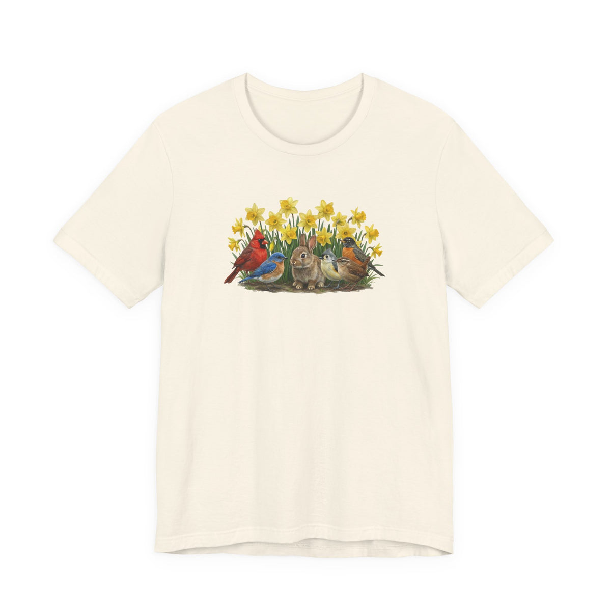 Light-colored soft t-shirt featuring a spring graphic: A rabbit sitting in yellow daffodils surrounded by a Northern Cardinal, Eastern Bluebird, and American Robin.