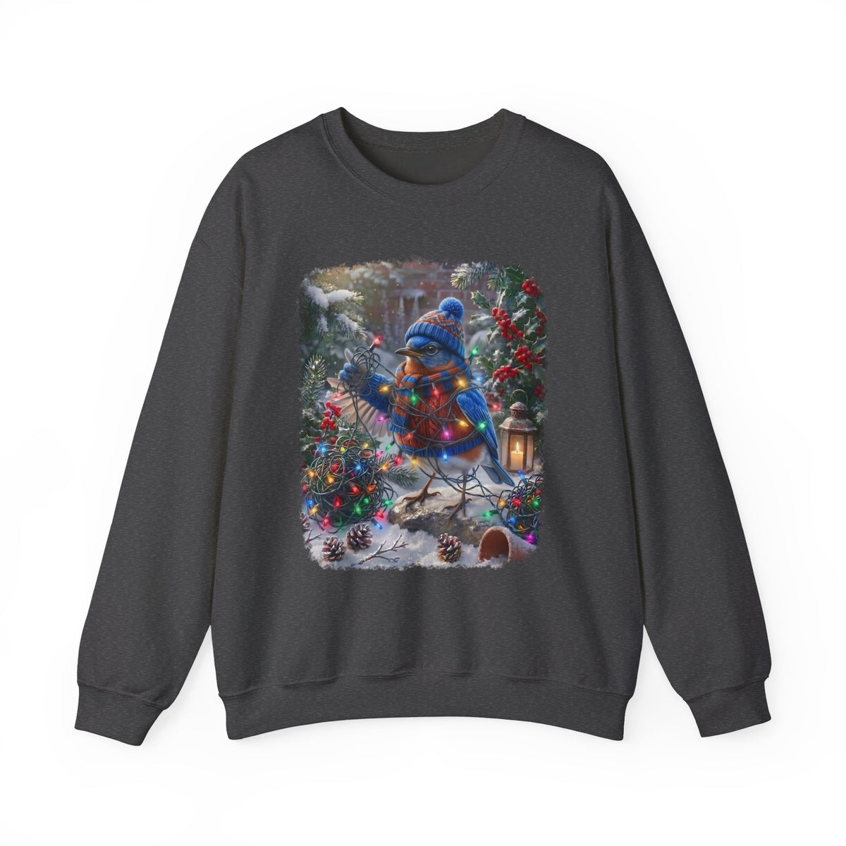 A dark gray crewneck sweatshirt featuring a large square graphic print on the front. The graphic depicts a festive winter scene with a bluebird wearing a blue knit hat and scarf, surrounded by decorated Christmas trees, pinecones, and a lantern in the snow.