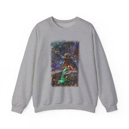 A heather gray crewneck sweatshirt featuring a large rectangular graphic print on the front. The graphic depicts a spooky scene with a robin bird in a hat watering a patch of green grass next to a pumpkin patch.