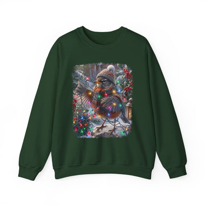 A dark green crewneck sweatshirt featuring a square graphic print of a robin wearing a knit hat and scarf, wrapped in Christmas lights next to a decorated Christmas tree.
