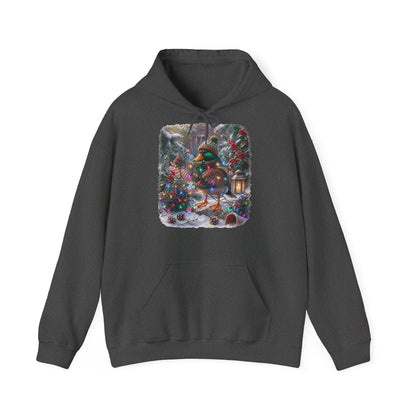 Ein dunkelgraues Kapuzen-Sweatshirt mit einem farbenfrohen Grafikdruck: eine Stockente in Winterkleidung und mit Mütze, die inmitten von Weihnachtsbäumen und Schnee eine Lichterkette hält.