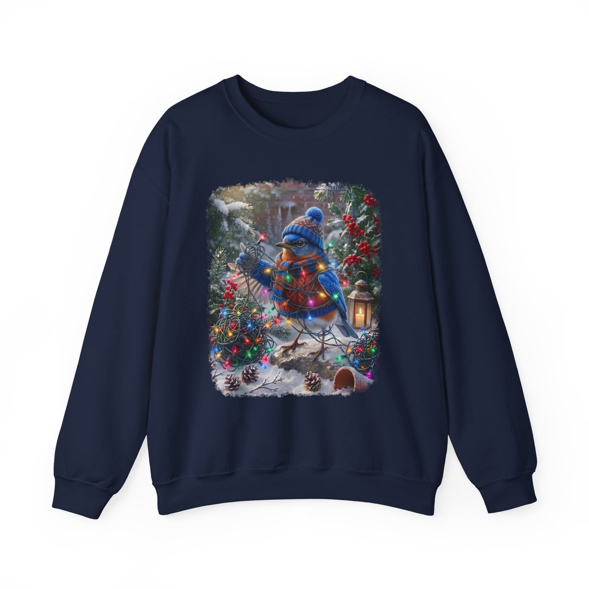 A navy blue crewneck sweatshirt featuring a large, colorful square graphic print on the front. The graphic depicts a festive winter scene with a bluebird in a blue knit hat and scarf, wrapped in warm holiday lights, standing in a snowy garden decorated with Christmas trees and pinecones.
