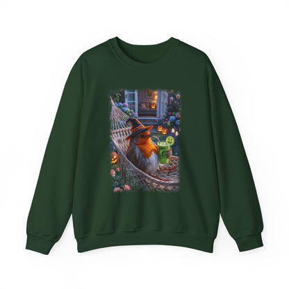A dark green crewneck sweatshirt featuring a large, colorful graphic print on the front of a robin bird wearing a witch hat and sitting in a hammock surrounded by Halloween decorations.