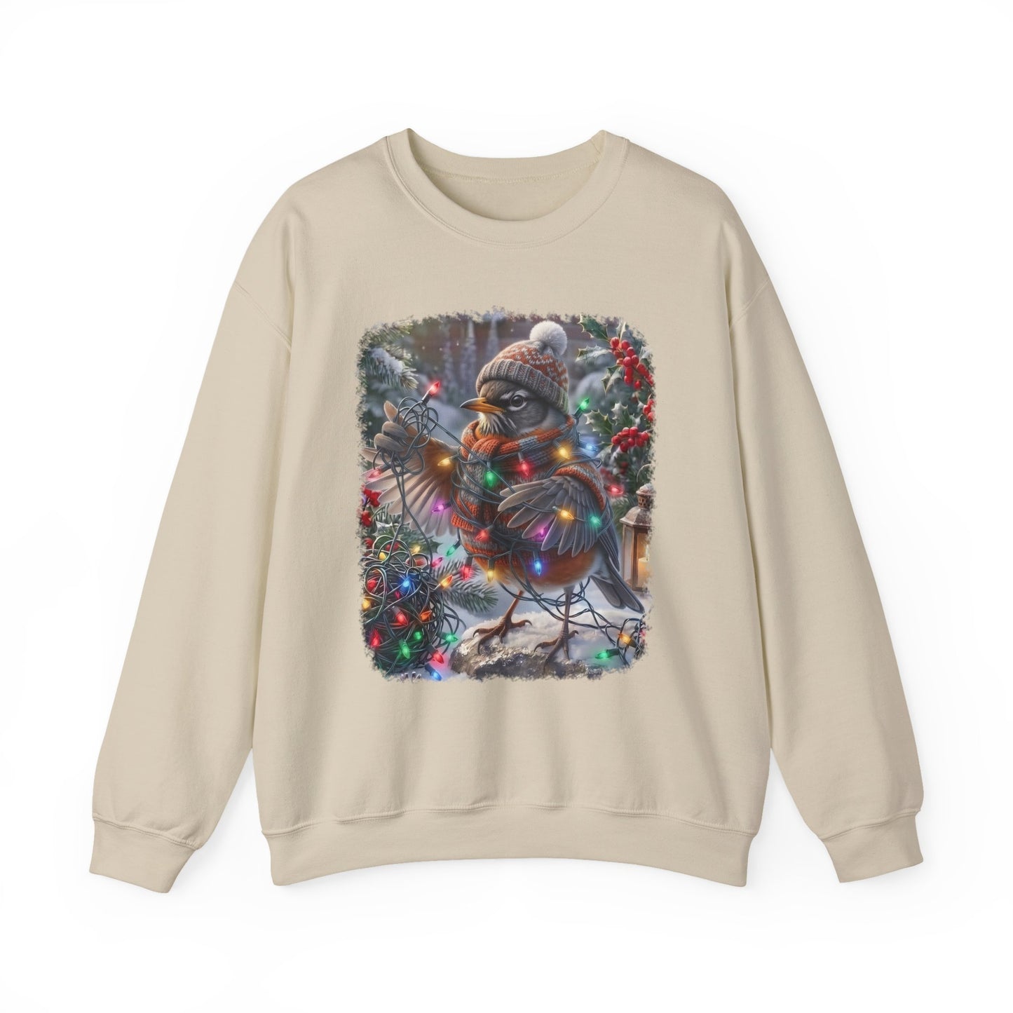 A beige crewneck sweatshirt featuring a square graphic print of a robin decorated for Christmas with a knit hat, scarf, and colorful holiday lights, set against a plain white background.
