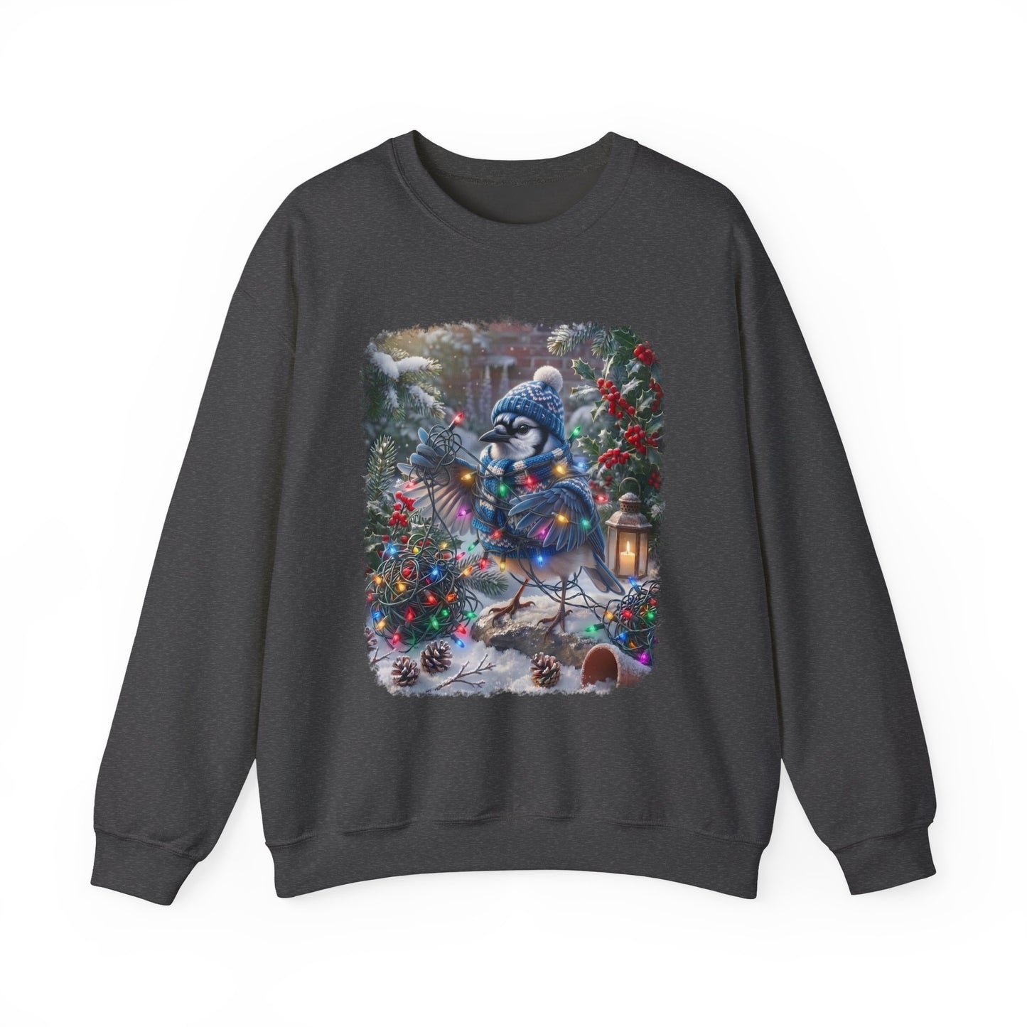 A dark gray crewneck sweatshirt featuring a large, colorful graphic print of a blue jay wearing a winter hat and scarf, nestled among decorated Christmas trees and pinecones in a snowy outdoor scene.