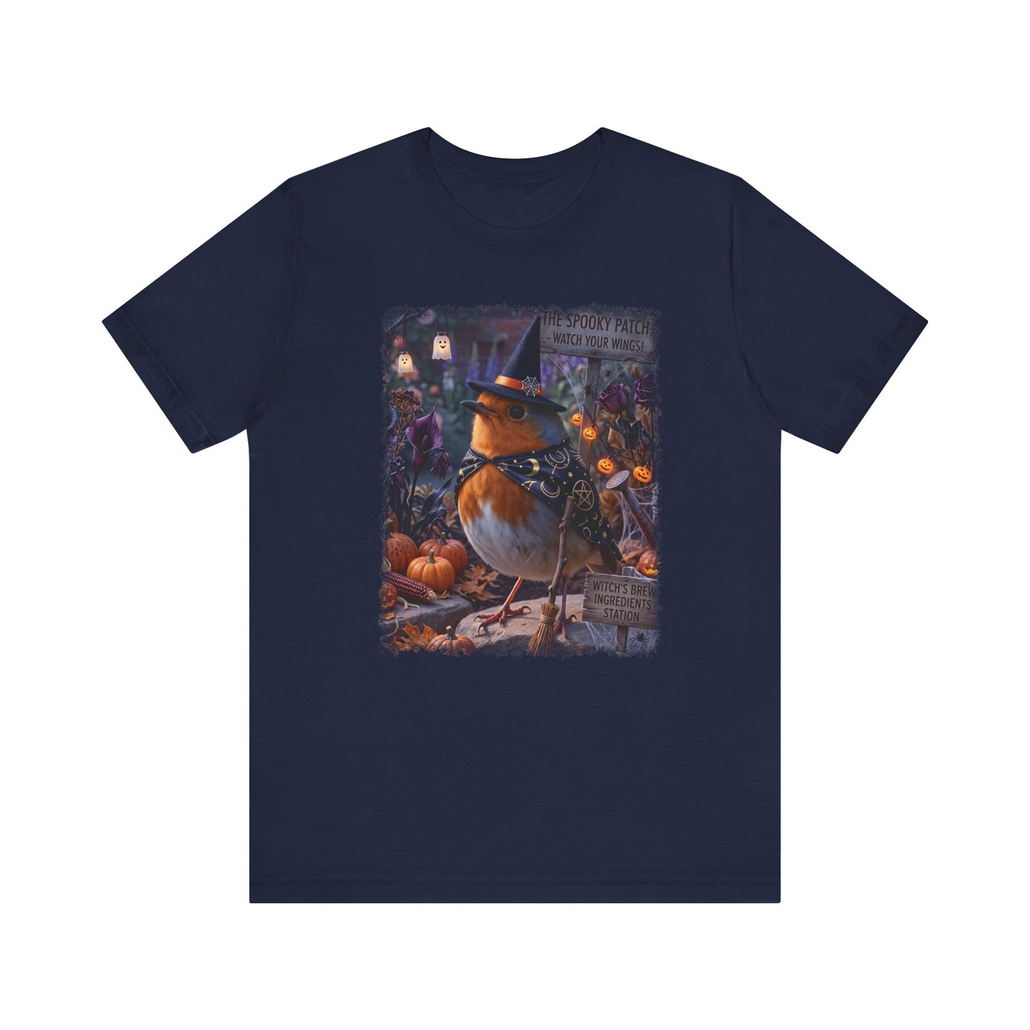 A navy blue short-sleeve crewneck t-shirt featuring a detailed graphic print of a robin wearing a witch hat in a spooky autumn setting with pumpkins and lanterns.
