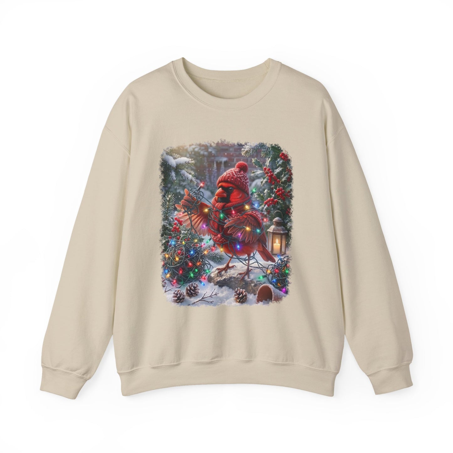 A beige crewneck sweatshirt featuring a colorful graphic print of a red cardinal dressed in a red knit Santa hat and scarf, perched on a decorated Christmas tree in the snow.