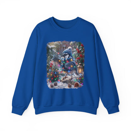 A royal blue crewneck sweatshirt featuring a large, colorful graphic print on the front of a snowy winter forest scene with a blue jay character wearing a knit hat and scarf.