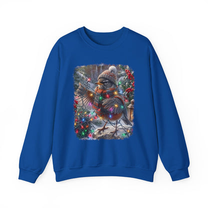 A royal blue crewneck sweatshirt featuring a large square graphic print on the front of a winter robin bird wearing a knit hat and scarf, surrounded by Christmas lights and evergreen trees.