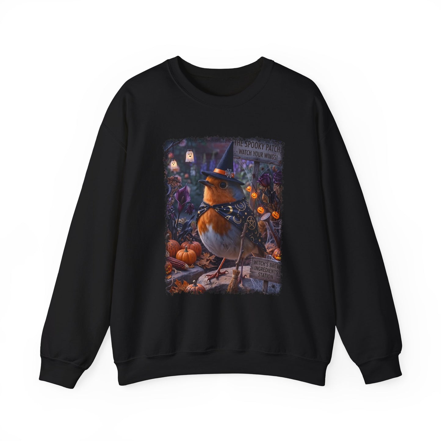A black crewneck sweatshirt featuring a colorful graphic print of a robin wearing a witch hat on a pumpkin stump in a spooky autumn scene.