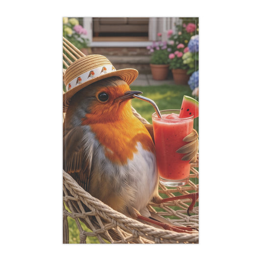 A vertical cotton kitchen towel featuring a small robin perched in a woven chair, wearing a straw hat and holding a glass of pink drink with a watermelon slice, set against a blurred garden background.