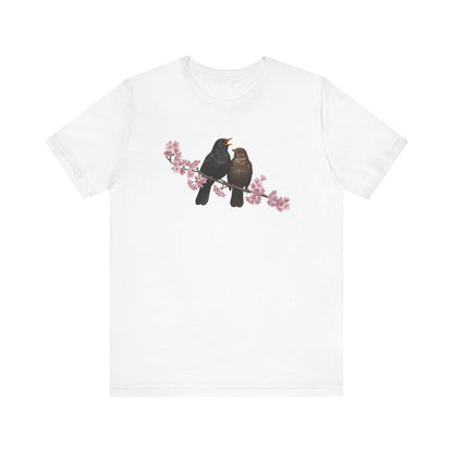 White t-shirt with two birds on a branch design on a white background