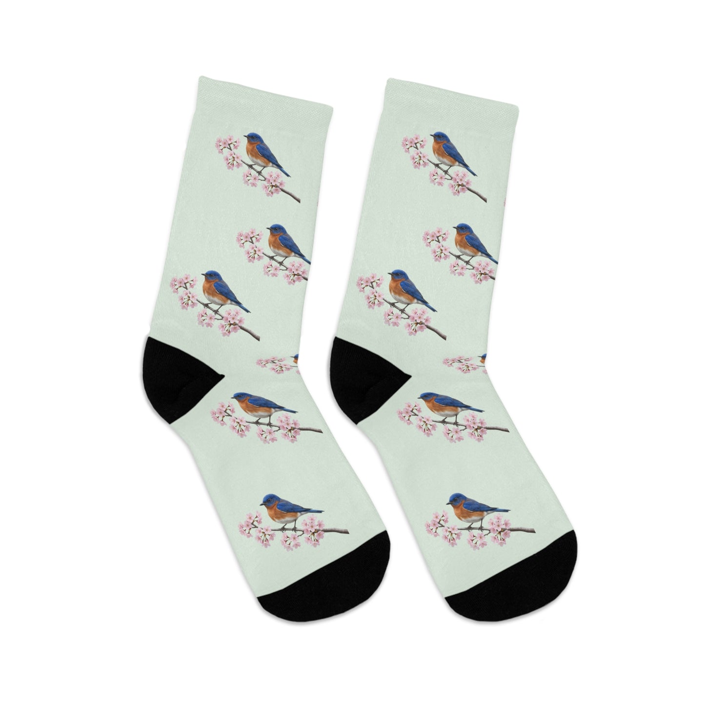 A pair of comfortable sage green socks featuring a seamless all-over print pattern of a vibrant Bluebird and delicate cherry blossoms. Eco-friendly birdwatching apparel.