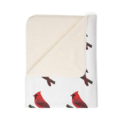 Folded blanket with red cardinal bird pattern on a white background