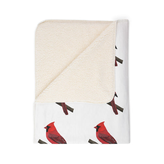 Folded blanket with red cardinal bird pattern on a white background