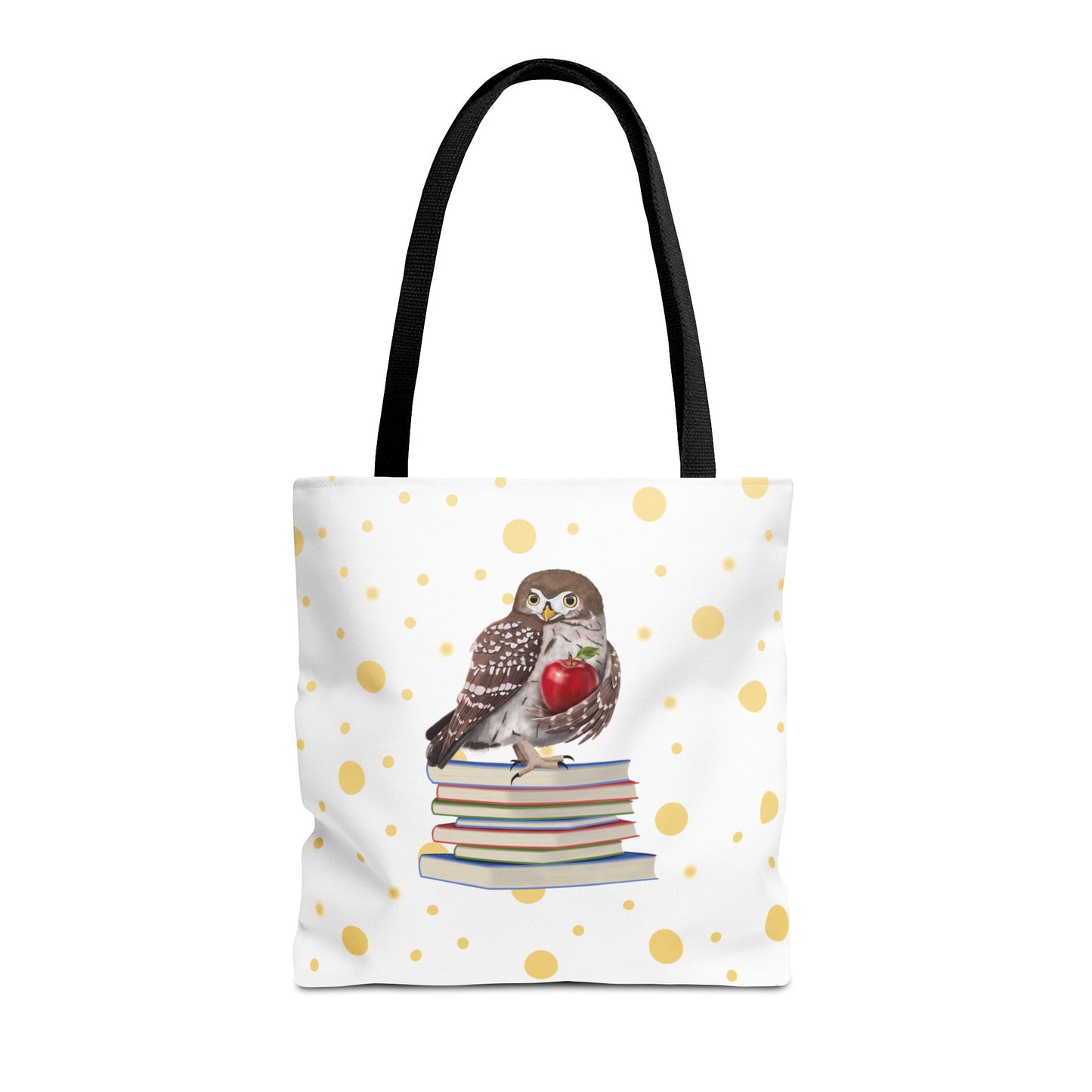 A white tote bag with black shoulder straps, decorated with a central illustration of a brown owl perched on a stack of books holding a red apple, and a scattered gold polka dot pattern across the bag.