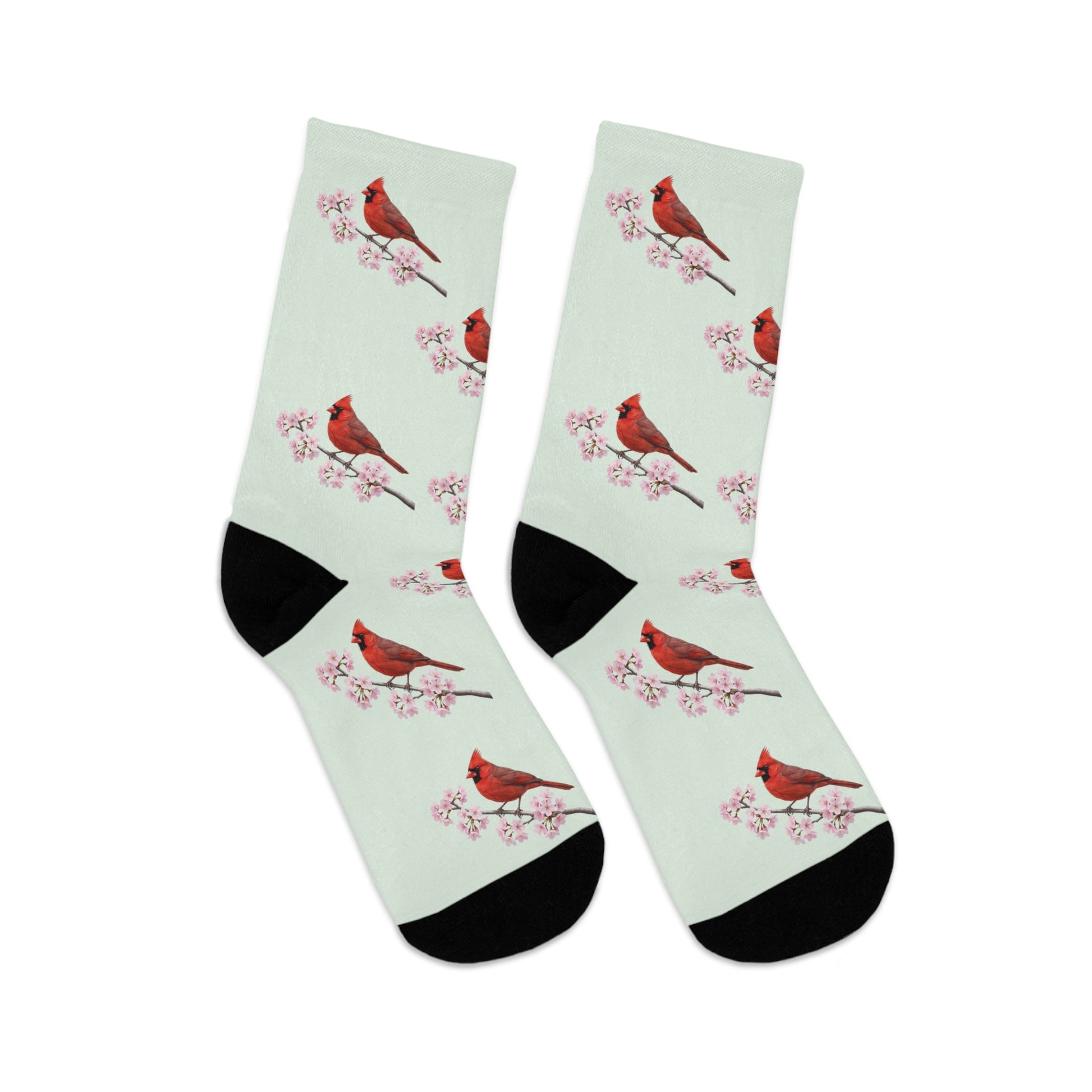 A pair of comfortable sage green socks featuring a seamless all-over print pattern of a vibrant Northern Cardinal and delicate cherry blossoms. Eco-friendly birdwatching apparel.