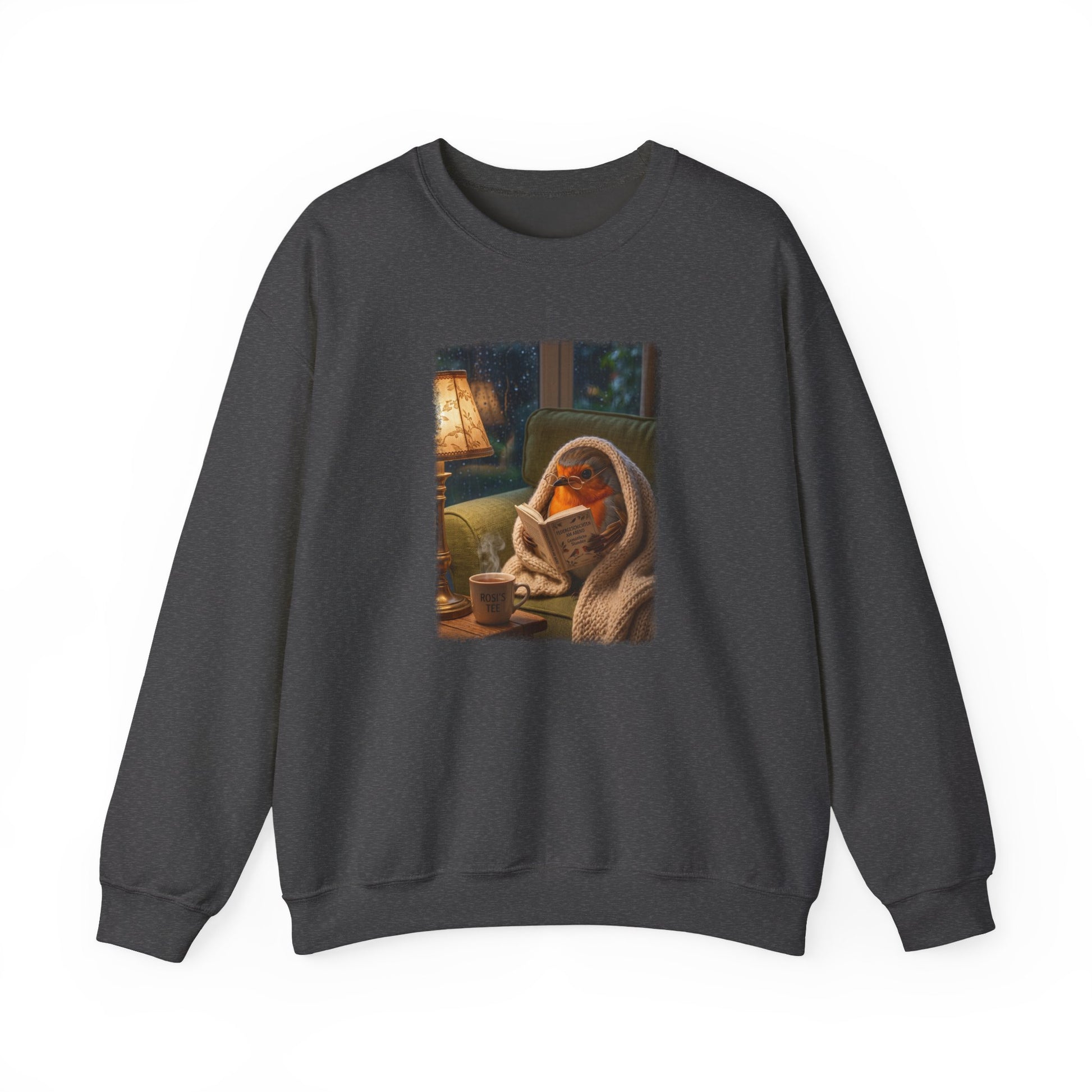 Soft unisex crewneck sweatshirt featuring a colorful front print. The digital illustration shows the cute bird Robin Rosi wrapped in a cozy blanket reading a book on the sofa. A great gift for a birdwatcher or bird lover.