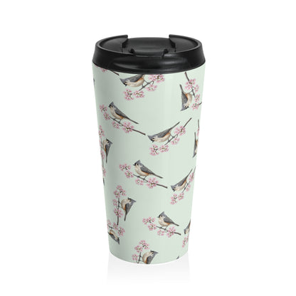 A premium 15oz stainless steel travel tumbler in sage green, featuring a seamless pattern of a Tufted Titmouse and cherry blossoms, with a black spill-proof lid. High-quality birdwatching coffee mug in e-commerce.
