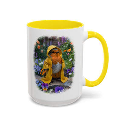 White ceramic coffee mug with a colored handle and interior. The digital illustration shows the cute bird Robin Rosi wearing a bright yellow raincoat in a garden. A wonderful gift for a birdwatcher or bird lover.