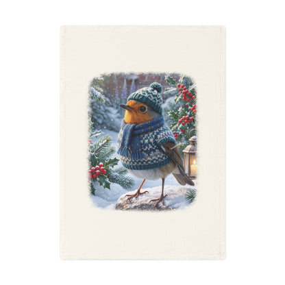 Winterliches Bio Geschirrtuch mit Vogelmotiv. Das Rotkehlchen Rosi trägt Strickmütze, Strickschal und Strickpullover in einem verschneiten Garten. Ein nachhaltiges Küchengeschenk für Vogelfreunde.