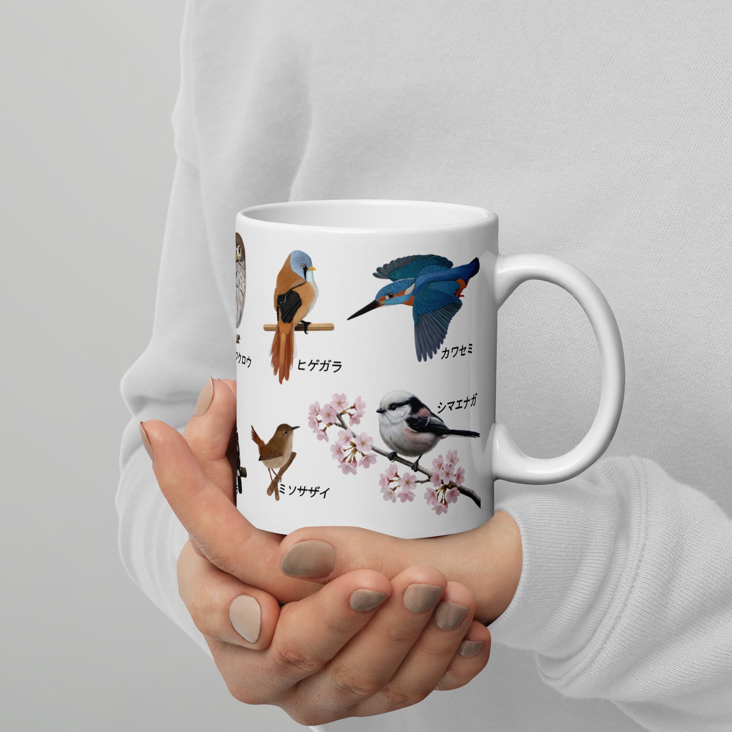 Person holding a mug with bird illustrations and text on a plain background